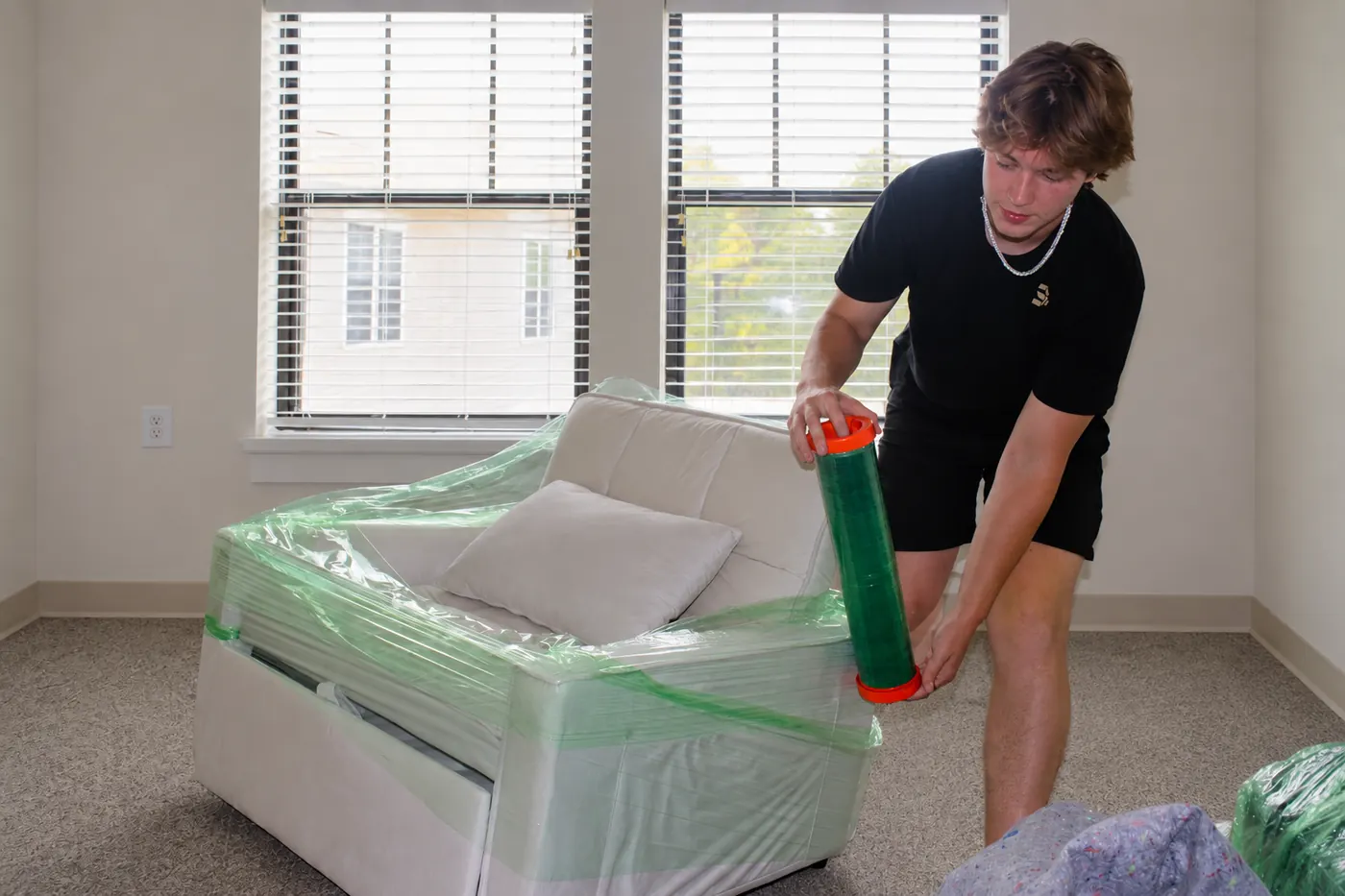 GoldStrap Moving crew member stretch-wrapping a white armchair before a move